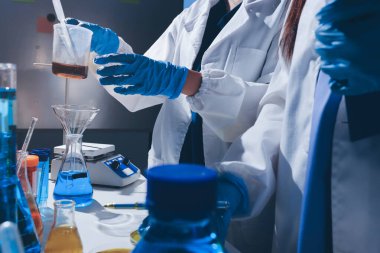 Bilimadamı laboratuarda tıbbi örnekleri mikro plakaya yerleştiriyor.