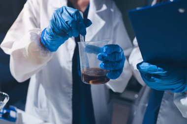 Bilimadamı laboratuarda tıbbi örnekleri mikro plakaya yerleştiriyor.