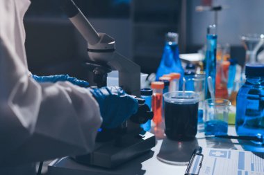 Bilimadamı laboratuarda tıbbi örnekleri mikro plakaya yerleştiriyor.