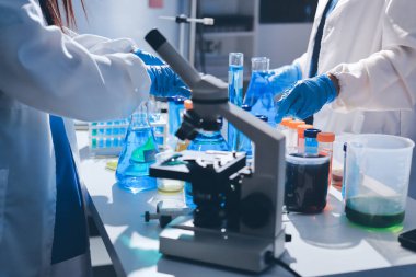 Bilimadamı laboratuarda tıbbi örnekleri mikro plakaya yerleştiriyor.