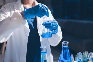 Bilimadamı laboratuarda tıbbi örnekleri mikro plakaya yerleştiriyor.