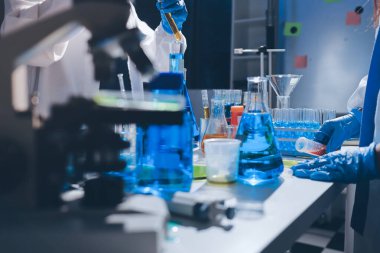 Bilimadamı laboratuarda tıbbi örnekleri mikro plakaya yerleştiriyor.