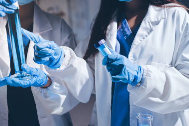 Bilimadamı laboratuarda tıbbi örnekleri mikro plakaya yerleştiriyor.