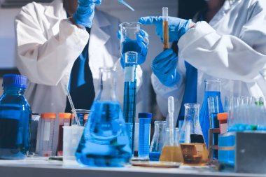 Bilimadamı laboratuarda tıbbi örnekleri mikro plakaya yerleştiriyor.