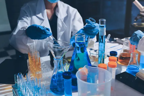 Bilimadamı laboratuarda tıbbi örnekleri mikro plakaya yerleştiriyor.