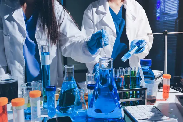 Bilimadamı laboratuarda tıbbi örnekleri mikro plakaya yerleştiriyor.