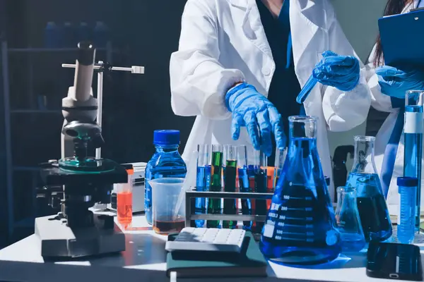 Bilimadamı laboratuarda tıbbi örnekleri mikro plakaya yerleştiriyor.