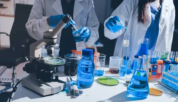 Bilimadamı laboratuarda tıbbi örnekleri mikro plakaya yerleştiriyor.