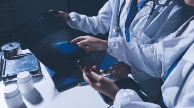 Erkek ve kadın doktorlar bir hastane odasında toplantı yapıyorlar..