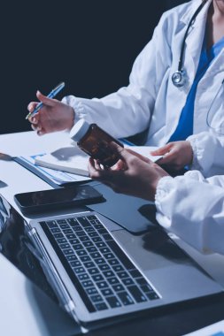 Erkek ve kadın doktorlar bir hastane odasında toplantı yapıyorlar..