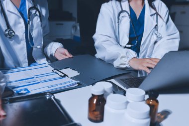 Erkek ve kadın doktorlar bir hastane odasında toplantı yapıyorlar..