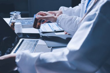 Erkek ve kadın doktorlar bir hastane odasında toplantı yapıyorlar..