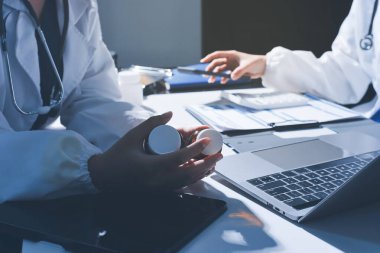 Erkek ve kadın doktorlar bir hastane odasında toplantı yapıyorlar..