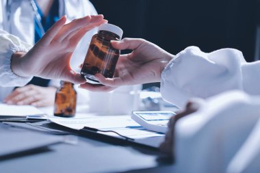 Erkek ve kadın doktorlar bir hastane odasında toplantı yapıyorlar..