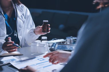 Erkek ve kadın doktorlar bir hastane odasında toplantı yapıyorlar..