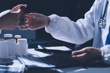 Erkek ve kadın doktorlar bir hastane odasında toplantı yapıyorlar..