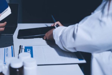 Erkek ve kadın doktorlar bir hastane odasında toplantı yapıyorlar..