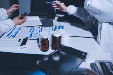 Erkek ve kadın doktorlar bir hastane odasında toplantı yapıyorlar..