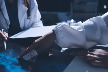 Erkek ve kadın doktorlar bir hastane odasında toplantı yapıyorlar..