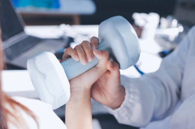 Tanımlanamayan fiziksel terapi sırasında mavi el ağırlığı kullanır