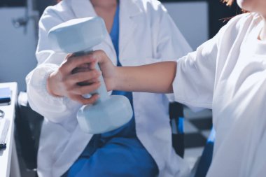 Tanımlanamayan fiziksel terapi sırasında mavi el ağırlığı kullanır