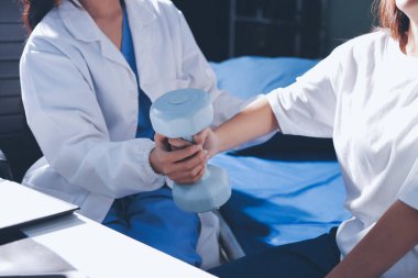 Tanımlanamayan fiziksel terapi sırasında mavi el ağırlığı kullanır