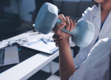 Tanımlanamayan fiziksel terapi sırasında mavi el ağırlığı kullanır