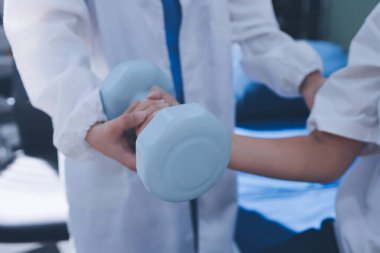 Tanımlanamayan fiziksel terapi sırasında mavi el ağırlığı kullanır