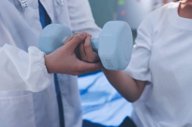 Tanımlanamayan fiziksel terapi sırasında mavi el ağırlığı kullanır