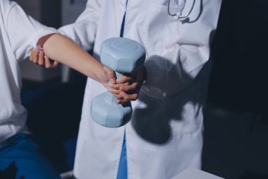 Tanımlanamayan fiziksel terapi sırasında mavi el ağırlığı kullanır