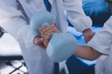 Tanımlanamayan fiziksel terapi sırasında mavi el ağırlığı kullanır