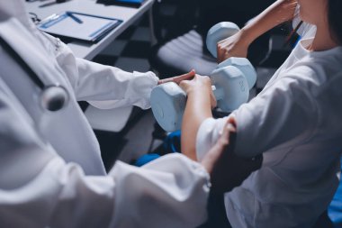 Tanımlanamayan fiziksel terapi sırasında mavi el ağırlığı kullanır