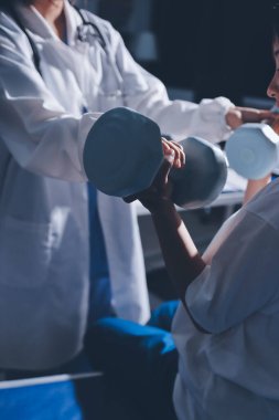 Tanımlanamayan fiziksel terapi sırasında mavi el ağırlığı kullanır