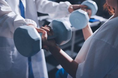 Tanımlanamayan fiziksel terapi sırasında mavi el ağırlığı kullanır