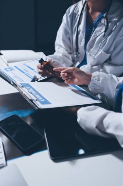 Erkek ve kadın doktorlar bir hastane odasında toplantı yapıyorlar..