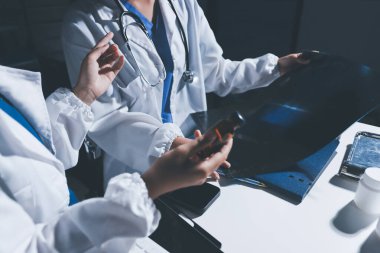 Erkek ve kadın doktorlar bir hastane odasında toplantı yapıyorlar..