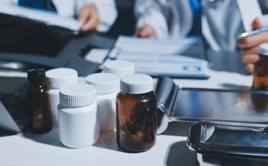 Erkek ve kadın doktorlar bir hastane odasında toplantı yapıyorlar..