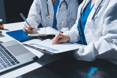 Erkek ve kadın doktorlar bir hastane odasında toplantı yapıyorlar..