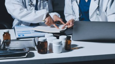 Erkek ve kadın doktorlar bir hastane odasında toplantı yapıyorlar..