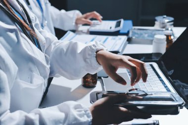 Erkek ve kadın doktorlar bir hastane odasında toplantı yapıyorlar..