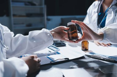 Erkek ve kadın doktorlar bir hastane odasında toplantı yapıyorlar..