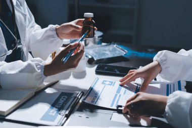 Erkek ve kadın doktorlar bir hastane odasında toplantı yapıyorlar..