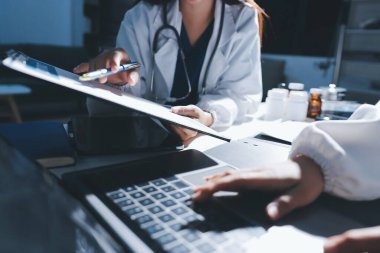 Erkek ve kadın doktorlar bir hastane odasında toplantı yapıyorlar..