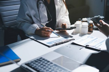 Erkek ve kadın doktorlar bir hastane odasında toplantı yapıyorlar..