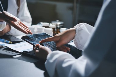 Erkek ve kadın doktorlar bir hastane odasında toplantı yapıyorlar..