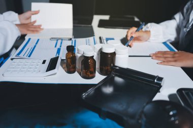 Erkek ve kadın doktorlar bir hastane odasında toplantı yapıyorlar..