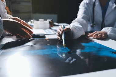 Erkek ve kadın doktorlar bir hastane odasında toplantı yapıyorlar..