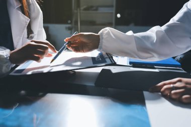 Erkek ve kadın doktorlar bir hastane odasında toplantı yapıyorlar..