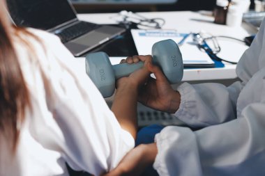 Tanımlanamayan fiziksel terapi sırasında mavi el ağırlığı kullanır