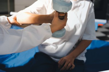 Tanımlanamayan fiziksel terapi sırasında mavi el ağırlığı kullanır